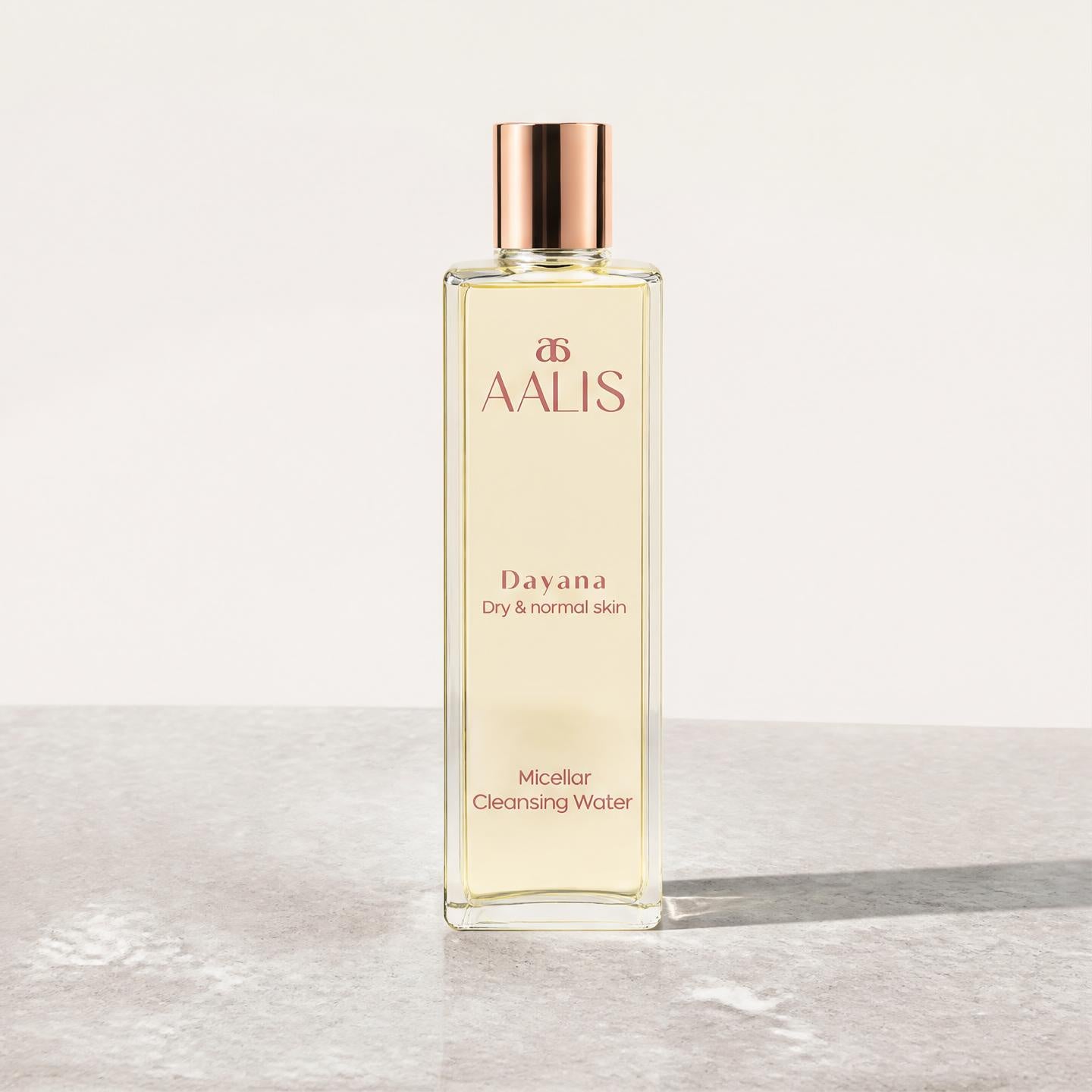 AALIS Dayana Micellar Cleansing Water bottle shown next to fresh water droplets.